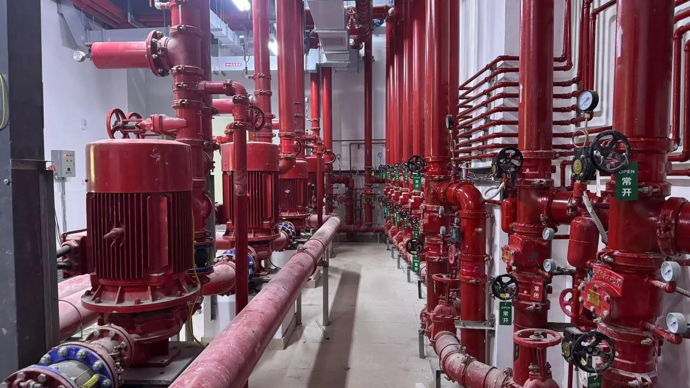 Row of sprinkler fire pump sets with OPEN and CLOSE position tags at an installed fire pump room